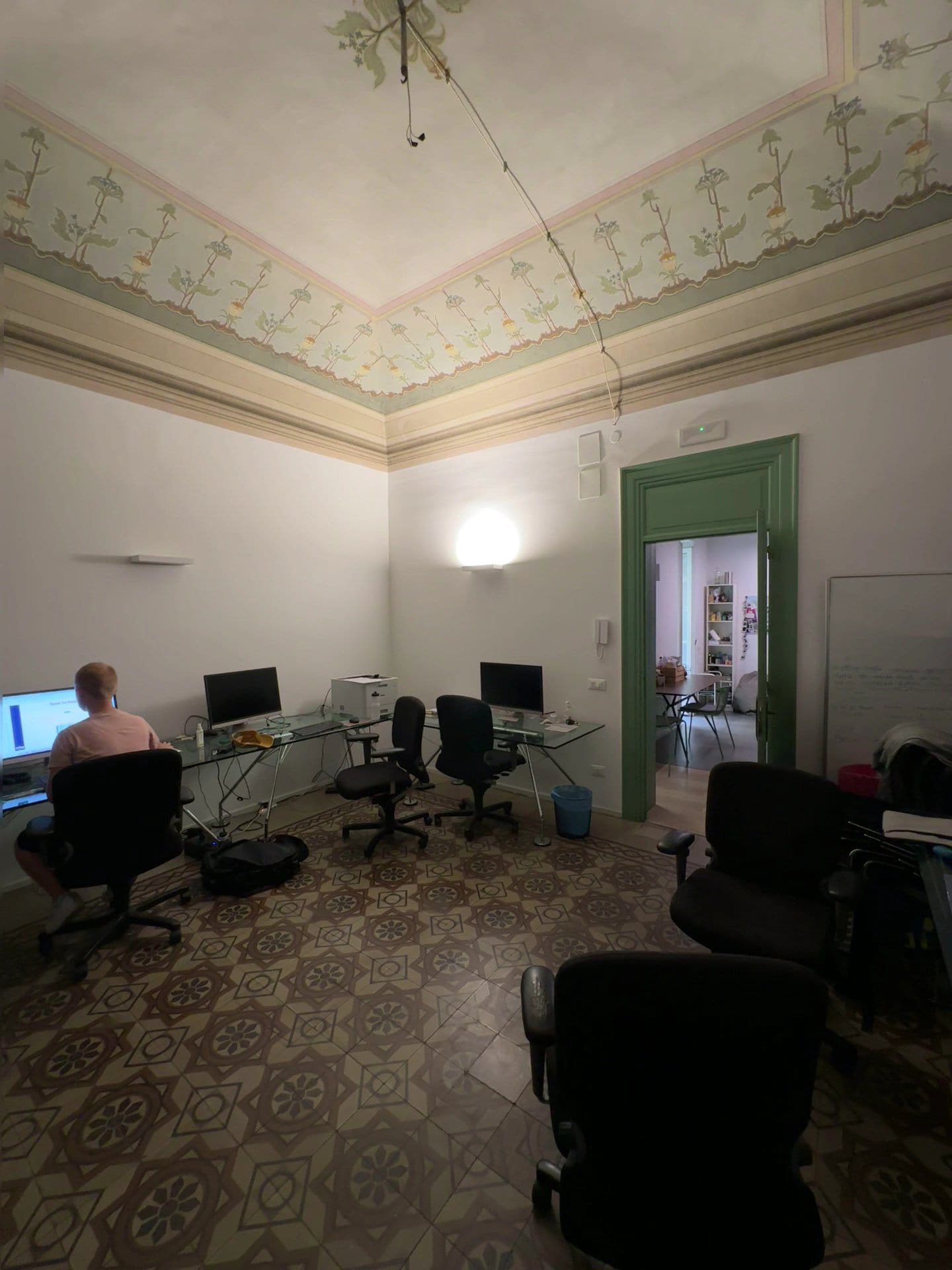 BeetCommunity members working at desktop workstations in the frescoed coworking room