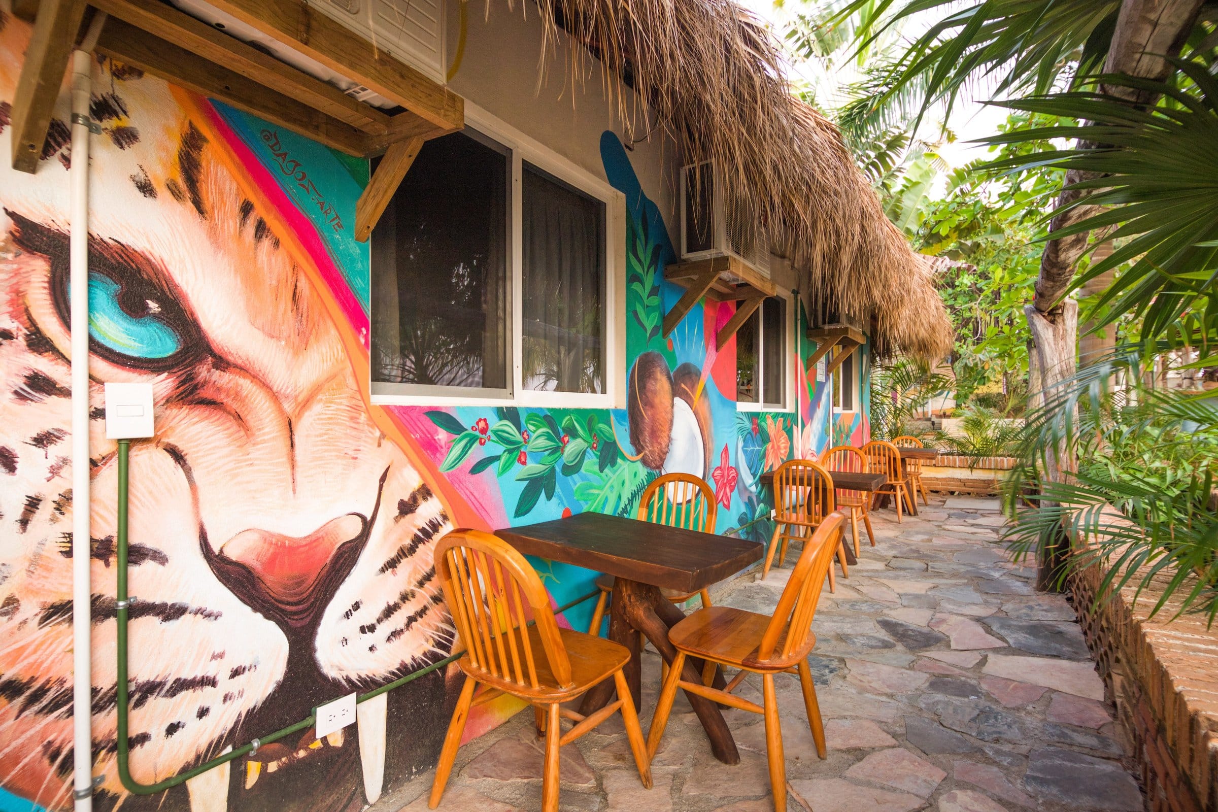 Colorful jaguar and jungle murals painted on the building exterior at Selina Puerto Escondido