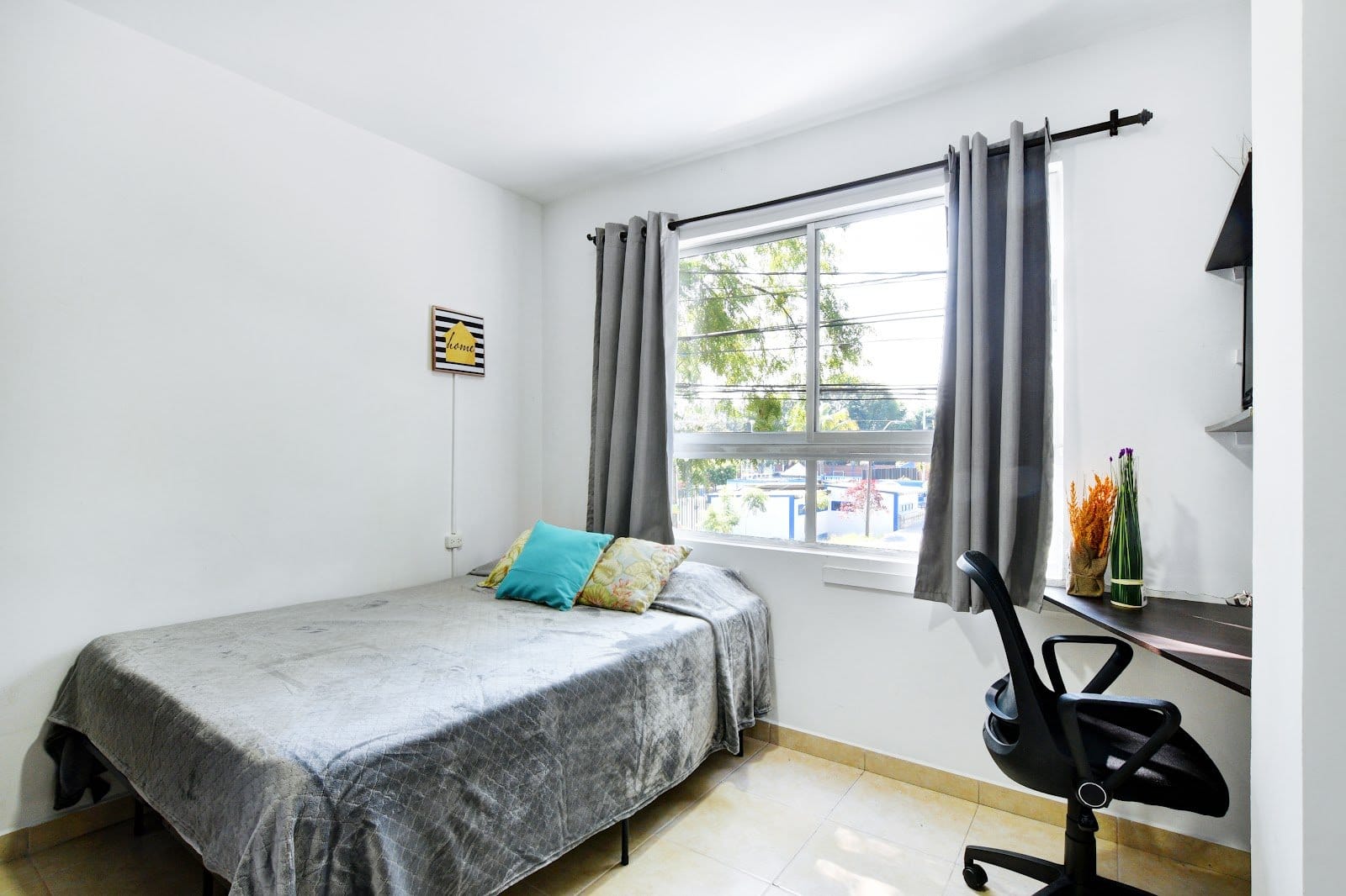 International House Co-Living bright private room with a double bed, study desk and large window letting in natural light