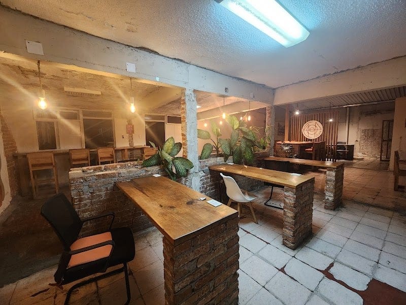 Coworking room at Co404 San Cristóbal with multiple wooden desks and office chairs