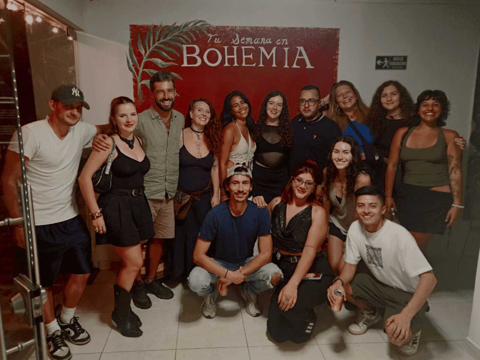 Guests gathered and smiling in front of the Bohemia mural at Bohemia Boutique Hostel Cali