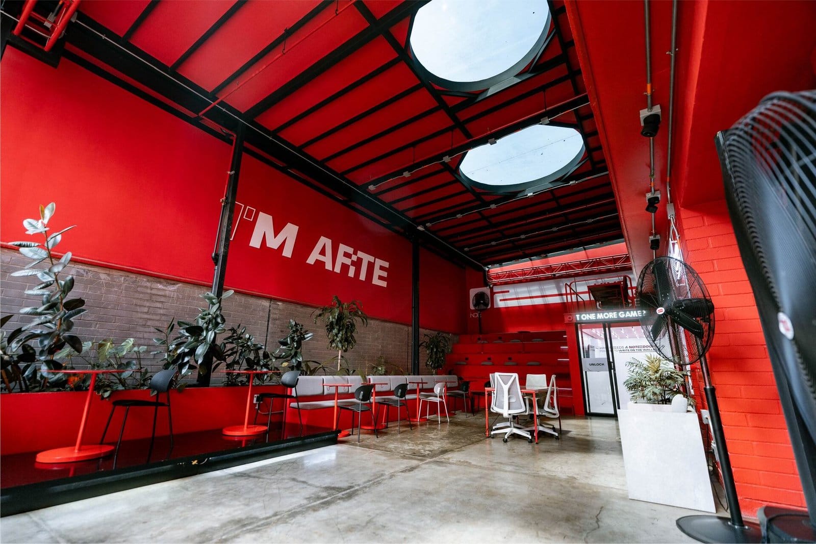 Terraza Marte rooftop lounge at Indie Studio with bold red walls, skylights and plants in Medellín