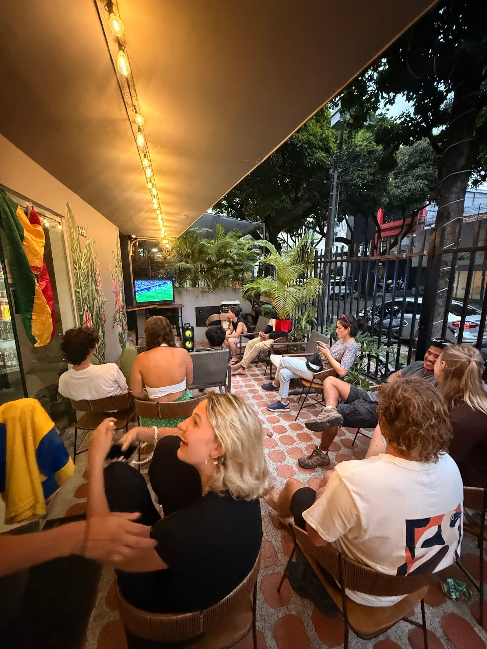 Guests socializing on the plant-filled terrace at Bohemia Boutique Hostel Cali
