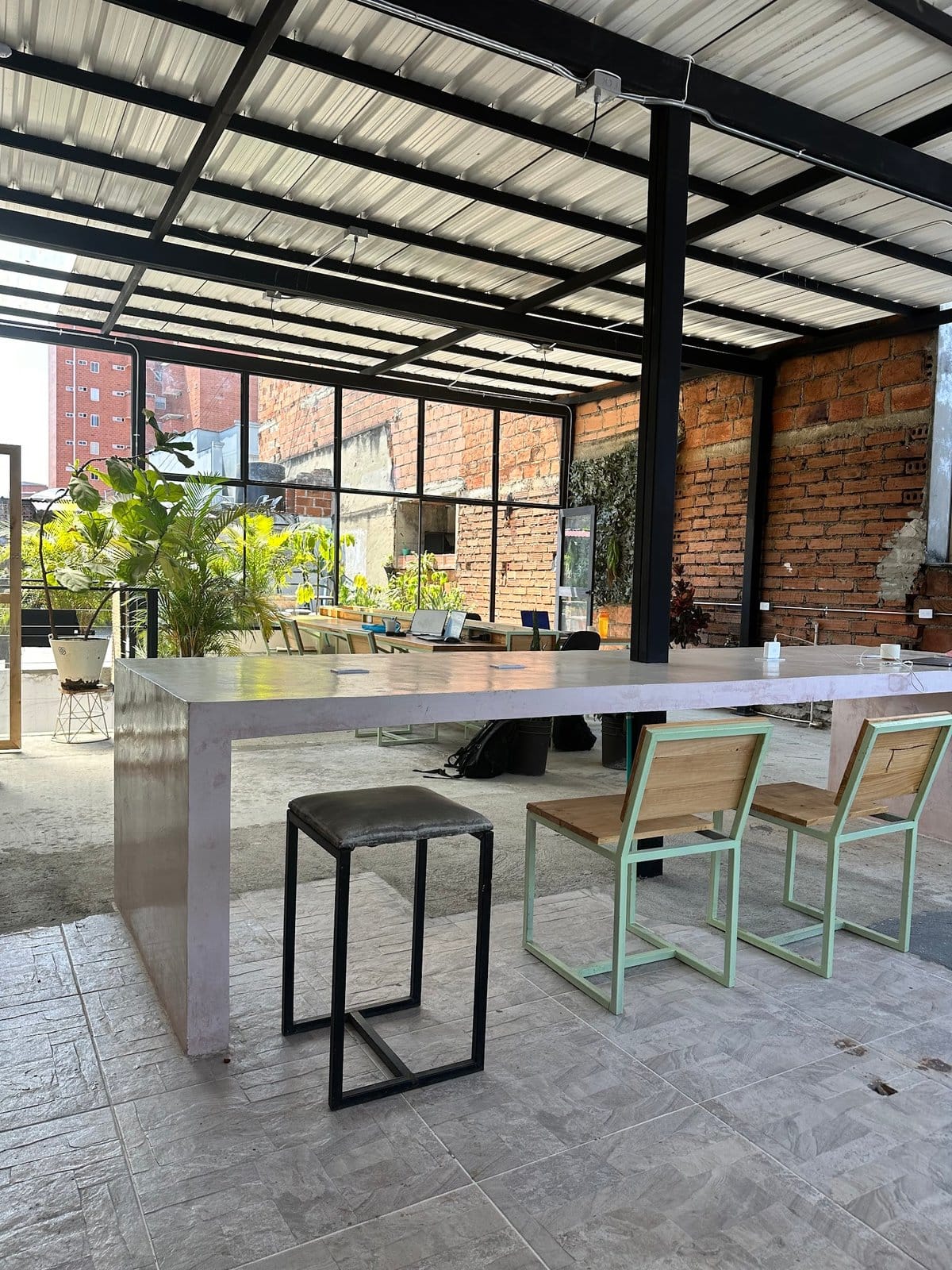 Open-air rooftop terrace coworking lounge with city views and greenery at Co404 Medellin
