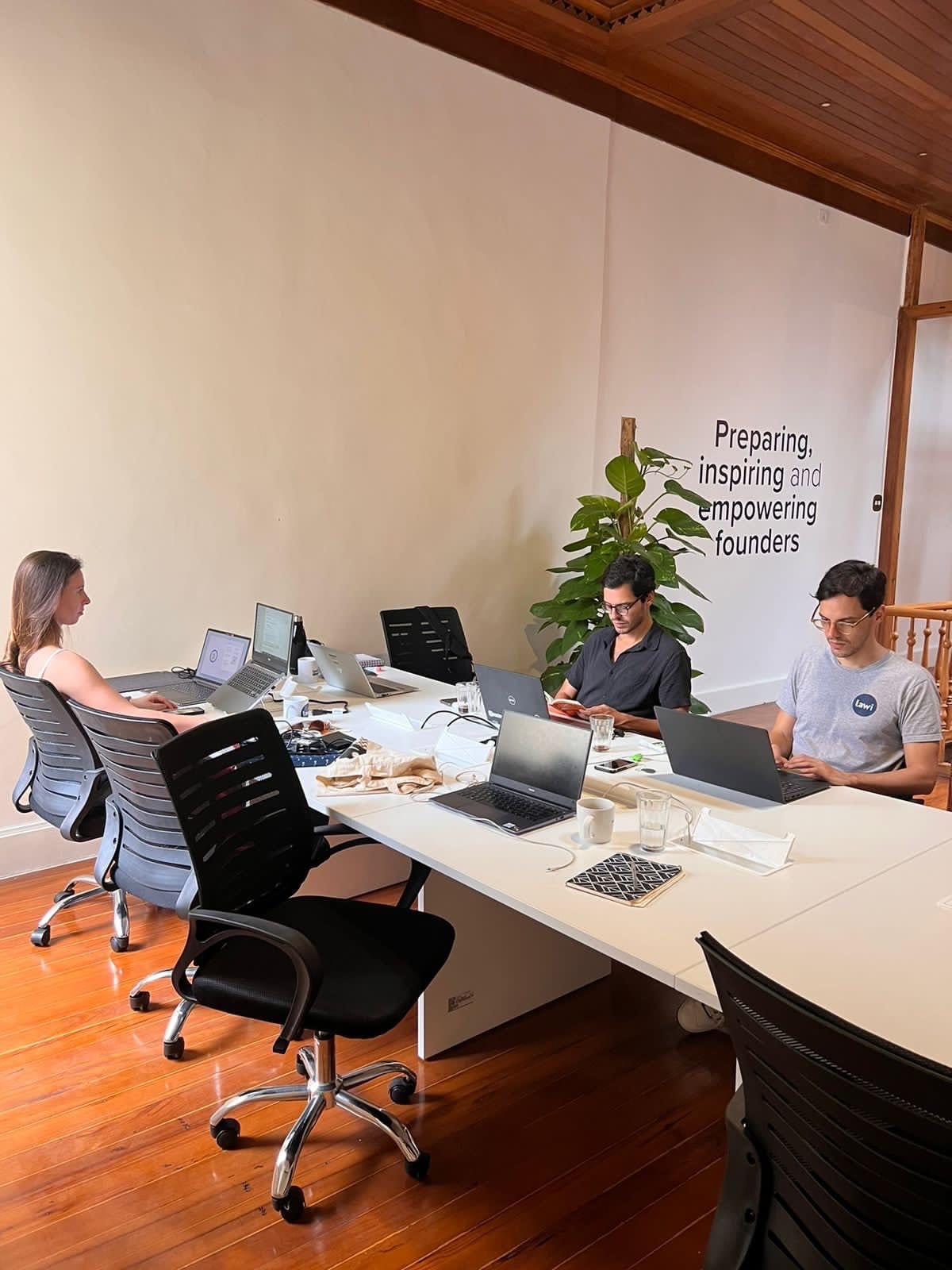 Members working on laptops at desks in the coworking space at Draper Startup House by Lawi, Rio de Janeiro