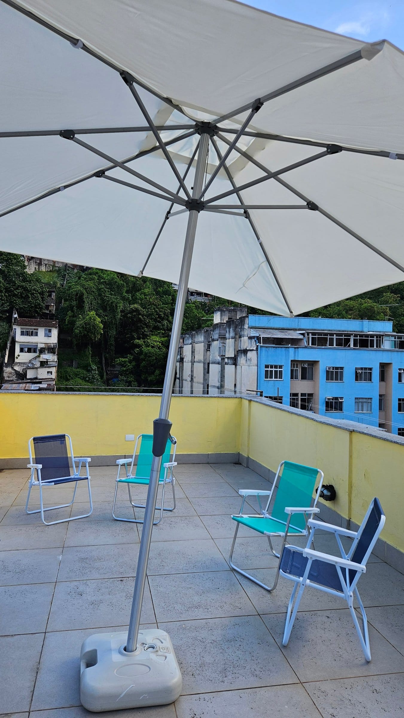 Rooftop terrace with shaded seating overlooking Rio de Janeiro at Draper Startup House by Lawi