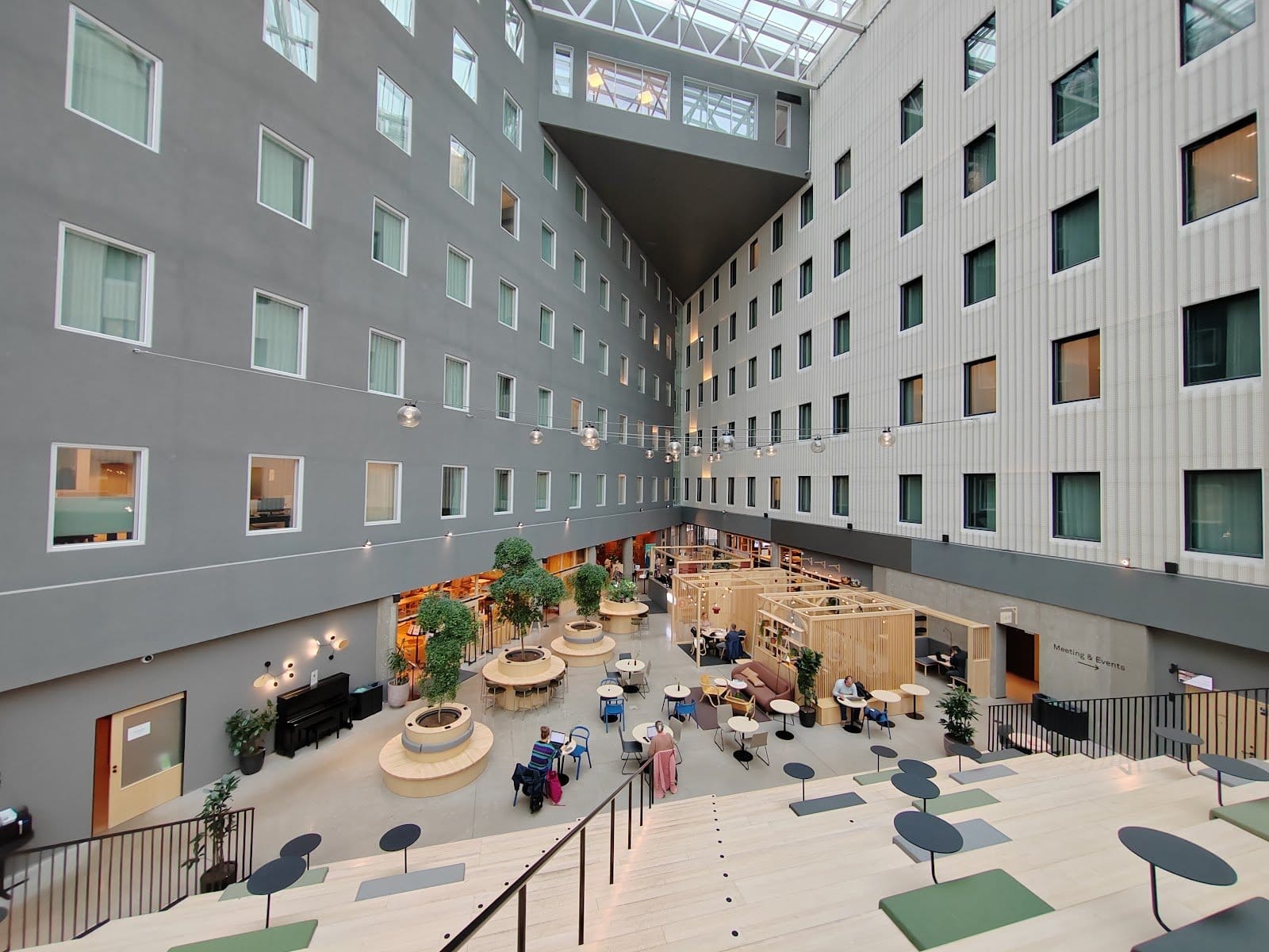 Large open atrium common space with nomads working and chatting at tables at VALO Hotel & Work