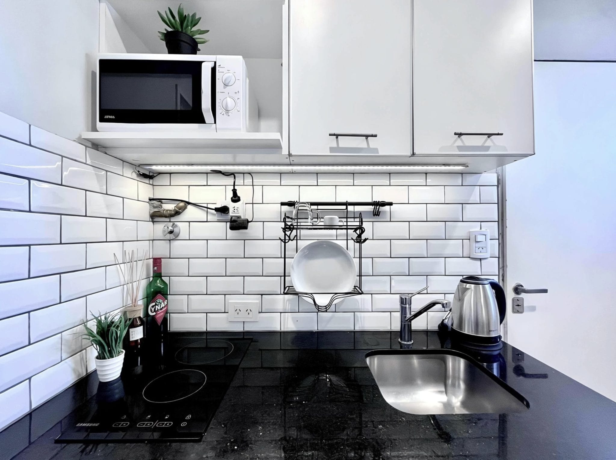 Modern shared kitchen with black countertop at Vibrant Coliving Buenos Aires