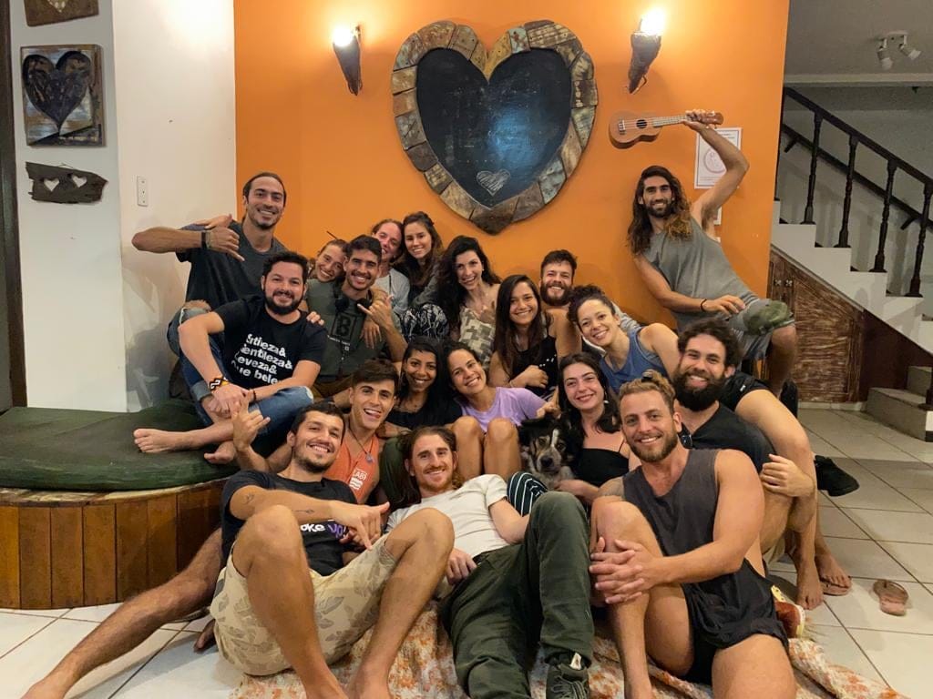 Guests gathered together by the heart wall art at Rosemary Dream Hostel & Coliving, Florianópolis