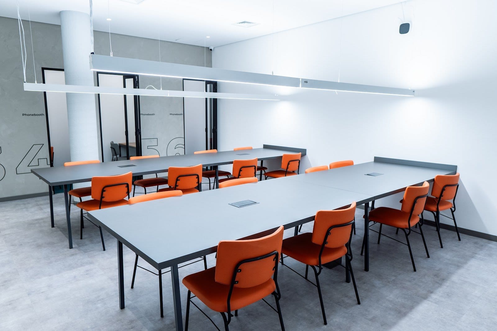 Shared study room with work tables, ergonomic chairs and phone booths at Uliving Campinas
