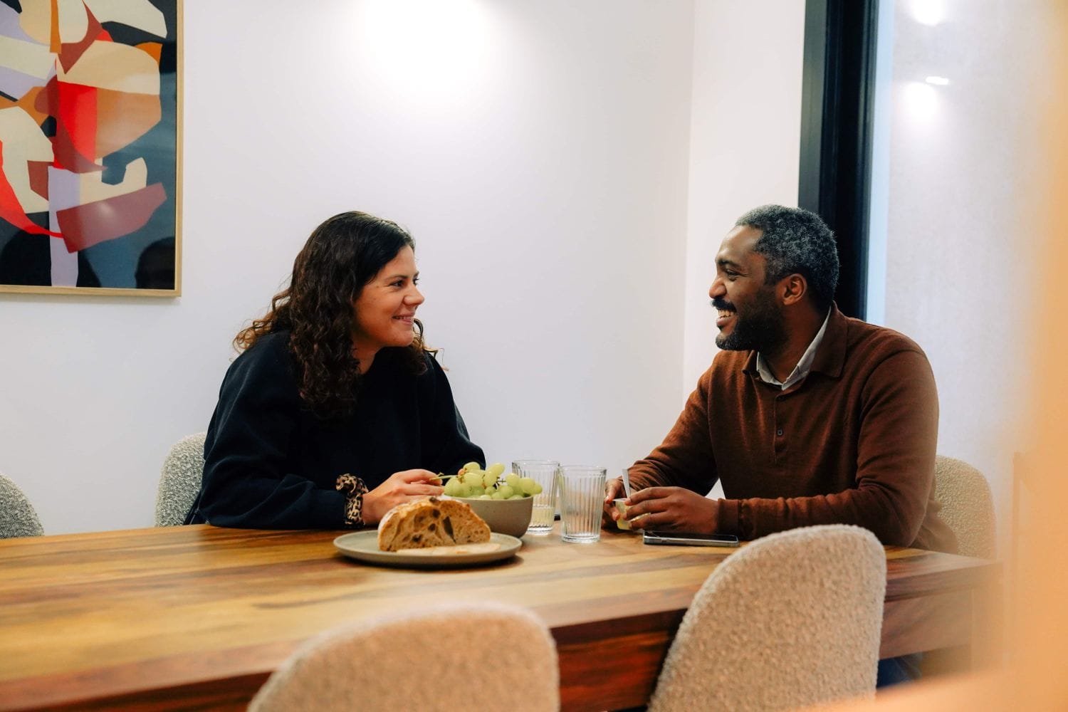 Two Outsite Bordeaux residents talking over lunch at the communal dining table
