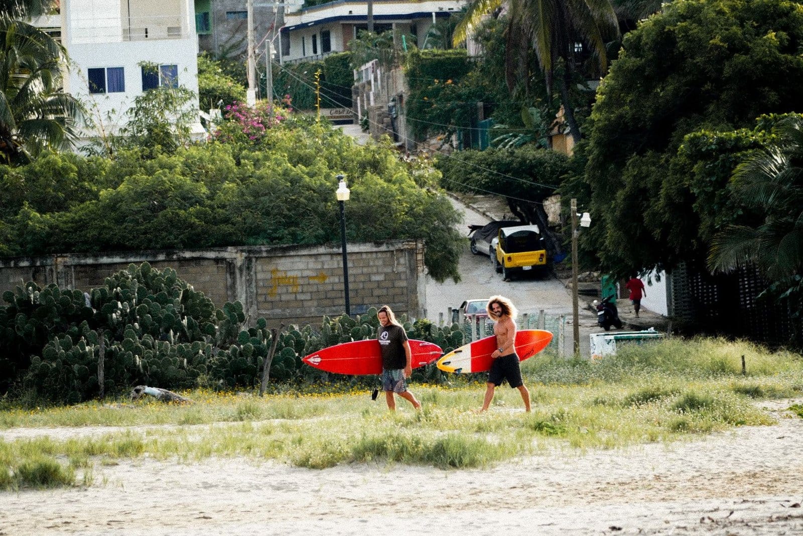 Flow Coliving guests heading to surf at Puerto Escondido beach with their boards