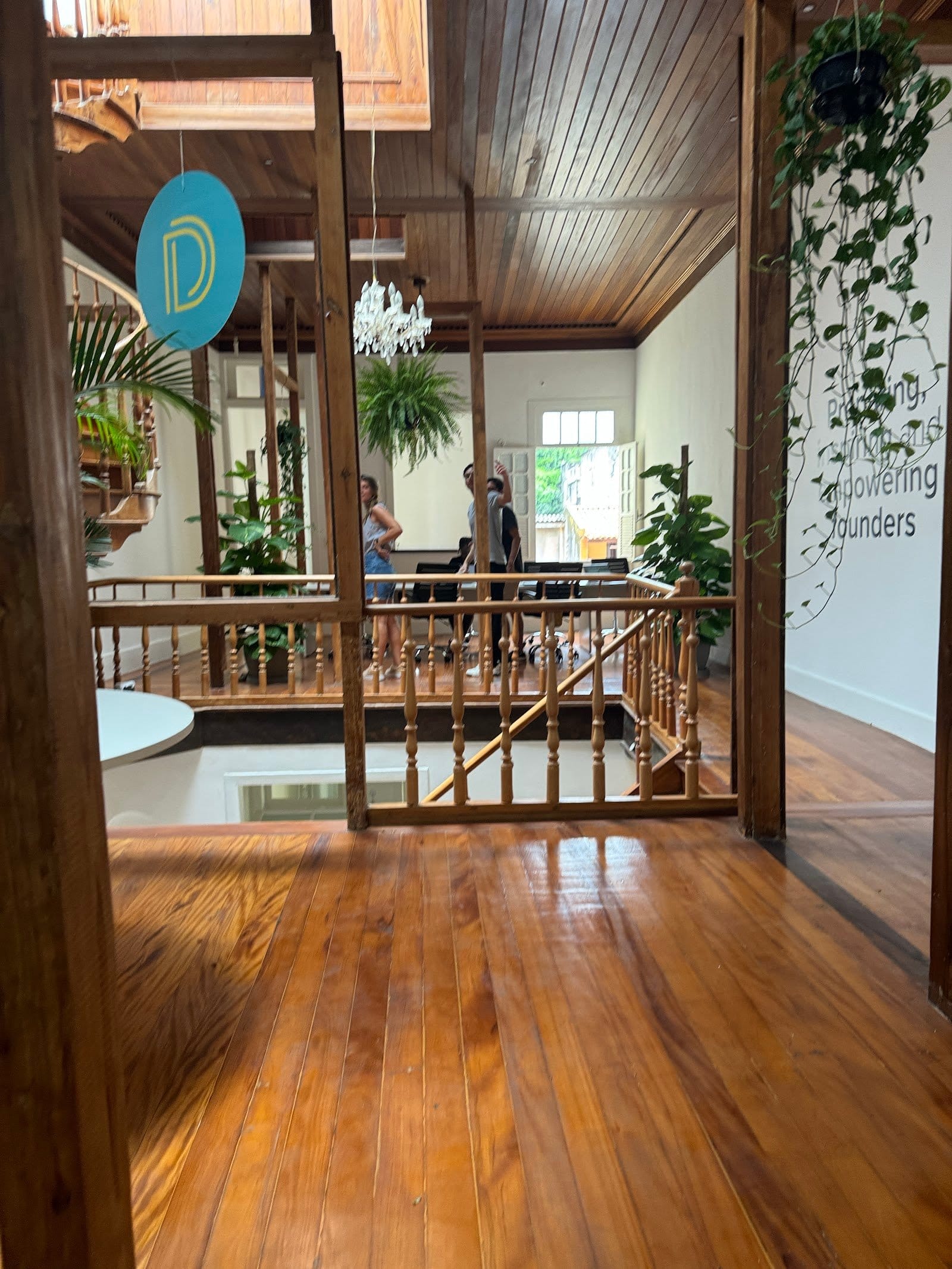 Guests chatting in the bright communal space at Draper Startup House by Lawi, Rio de Janeiro