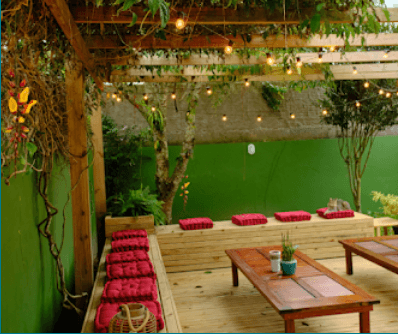 Cozy rooftop terrace with string lights and cushioned seating at Coliving Muní