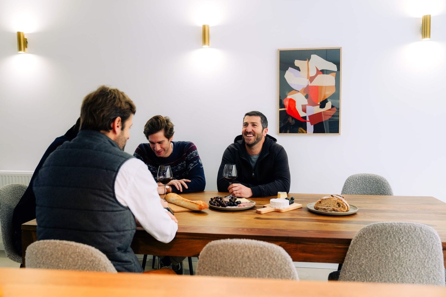 Three Outsite Bordeaux residents sharing a casual meal at the communal dining table