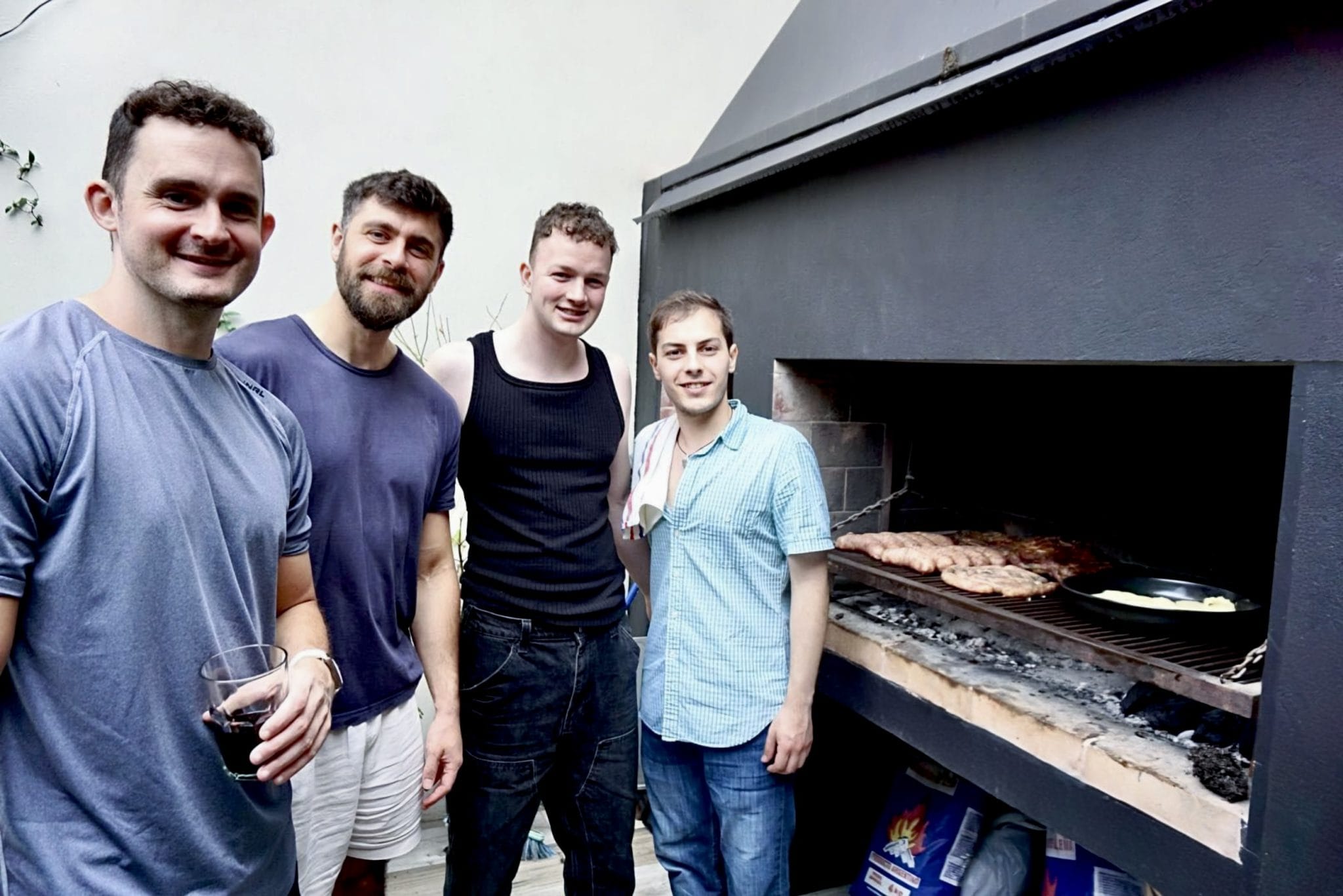 Residents smiling beside the outdoor grill on the terrace at Vibrant Coliving Buenos Aires