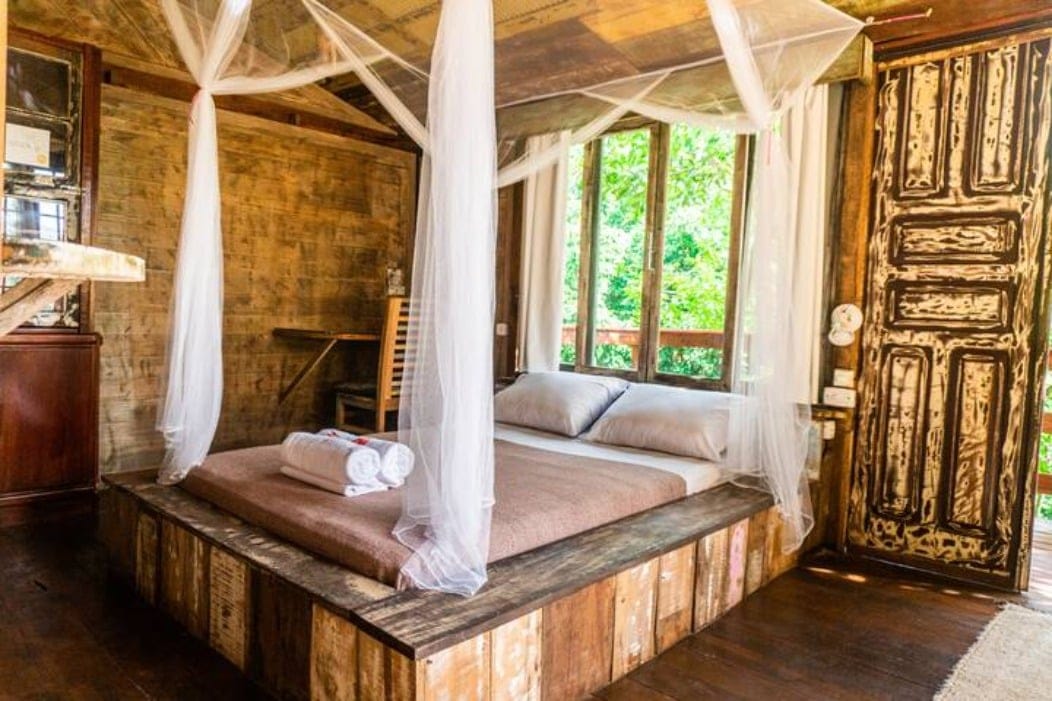 Rustic wooden private room with canopy bed and forest view at Rosemary Dream Hostel & Coliving, Florianópolis