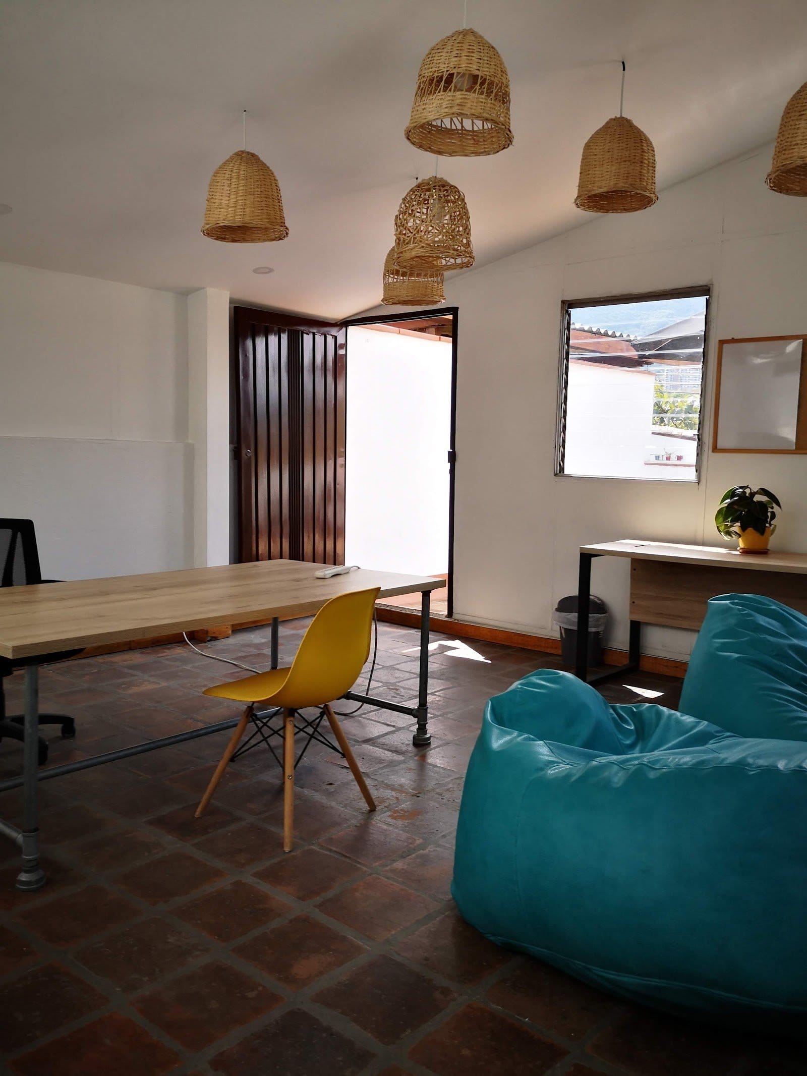 Dedicated coworking room at Tribu Coliving with wooden work tables, office chair, beanbags and natural light
