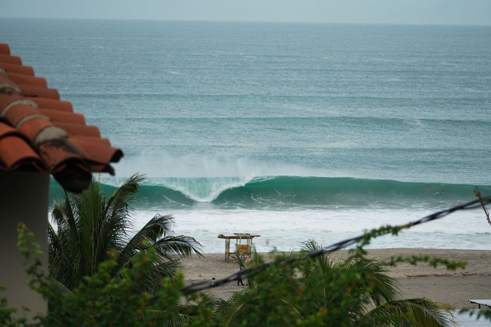 Iconic Puerto Escondido wave breaking at Zicatela Beach viewed from Flow Coliving rooftop