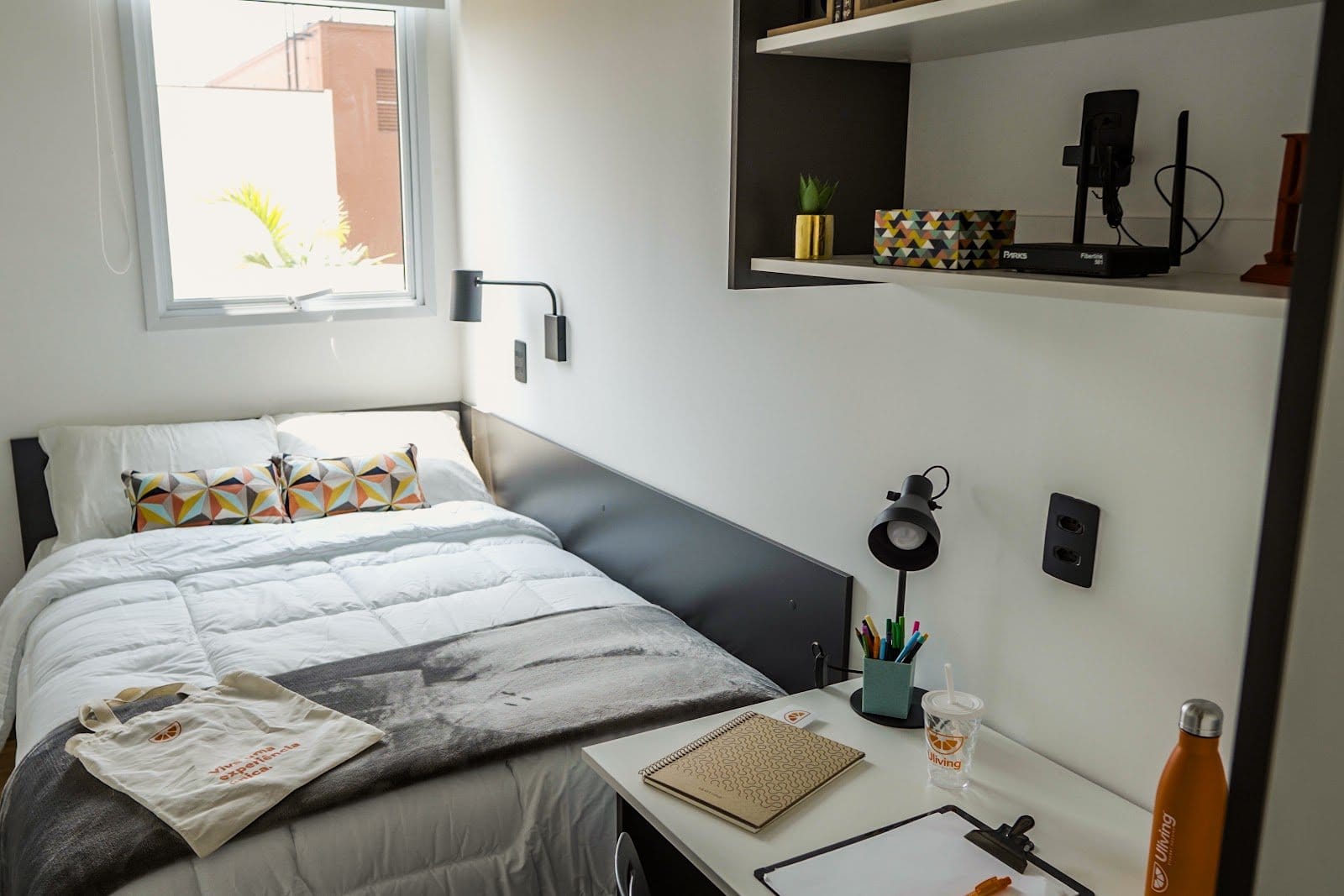Furnished student bedroom with study desk and made bed at Uliving Campinas