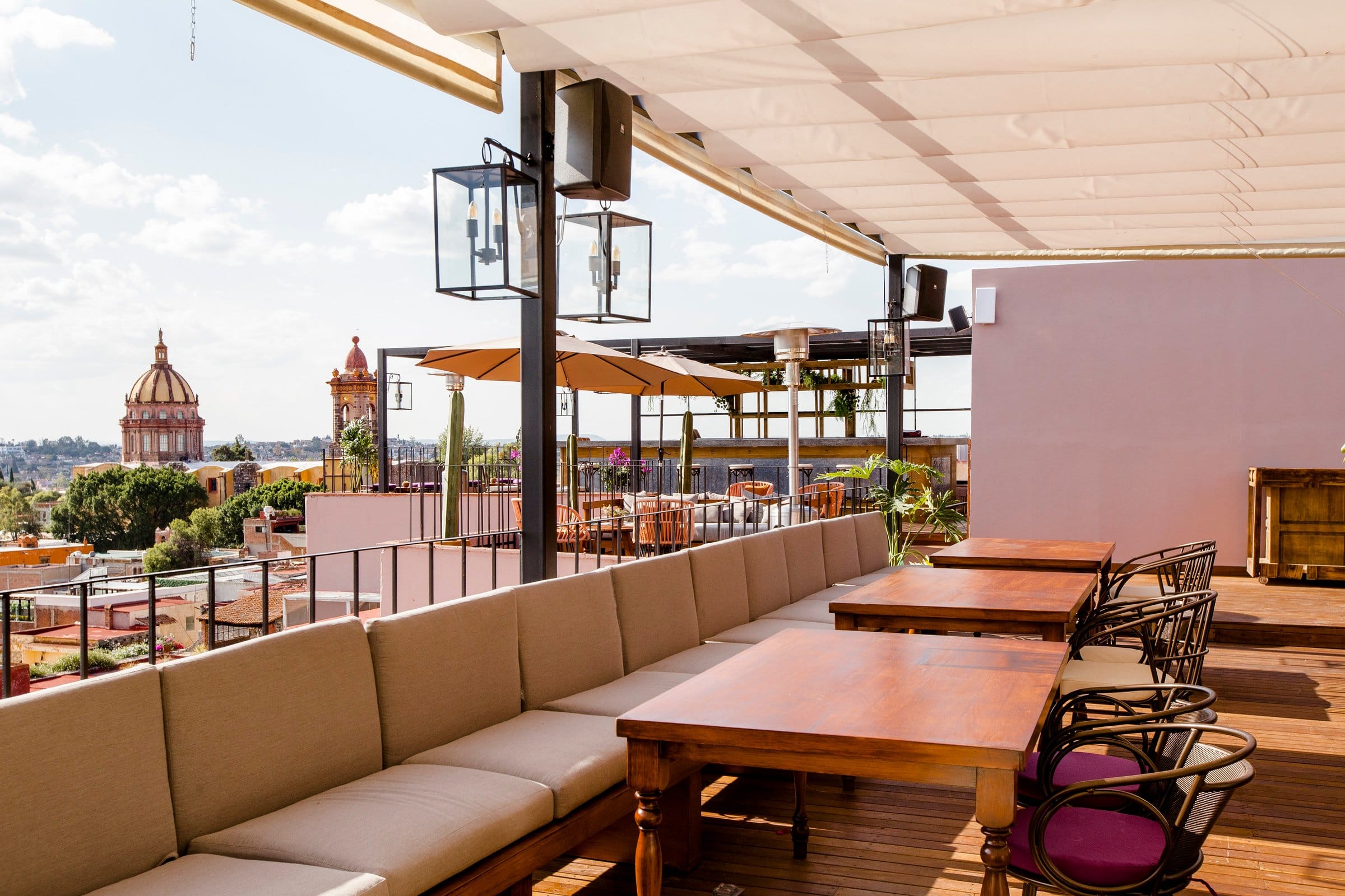 Rooftop bar and lounge at Selina San Miguel de Allende with panoramic city view and the historic cathedral dome in the background