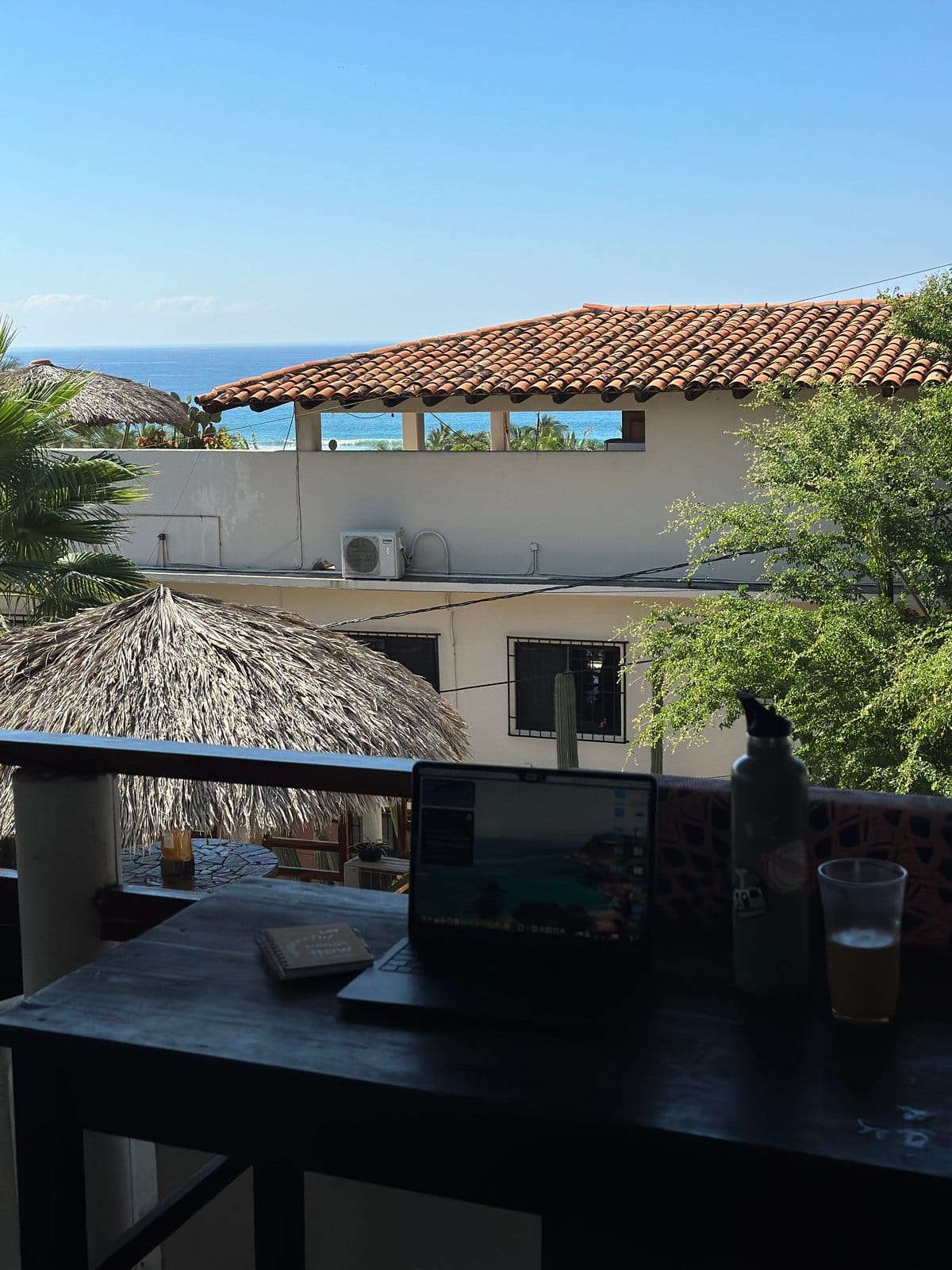 Working from the upper balcony at Flow Coliving with Pacific Ocean view and palapa below