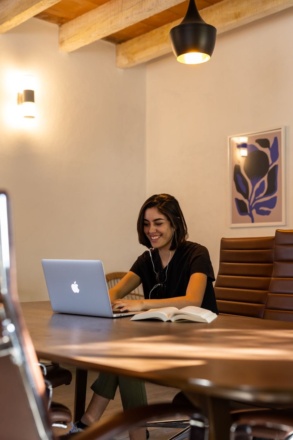 Digital nomad working on laptop at the coworking table at Outsite San Miguel de Allende with wooden beam ceiling
