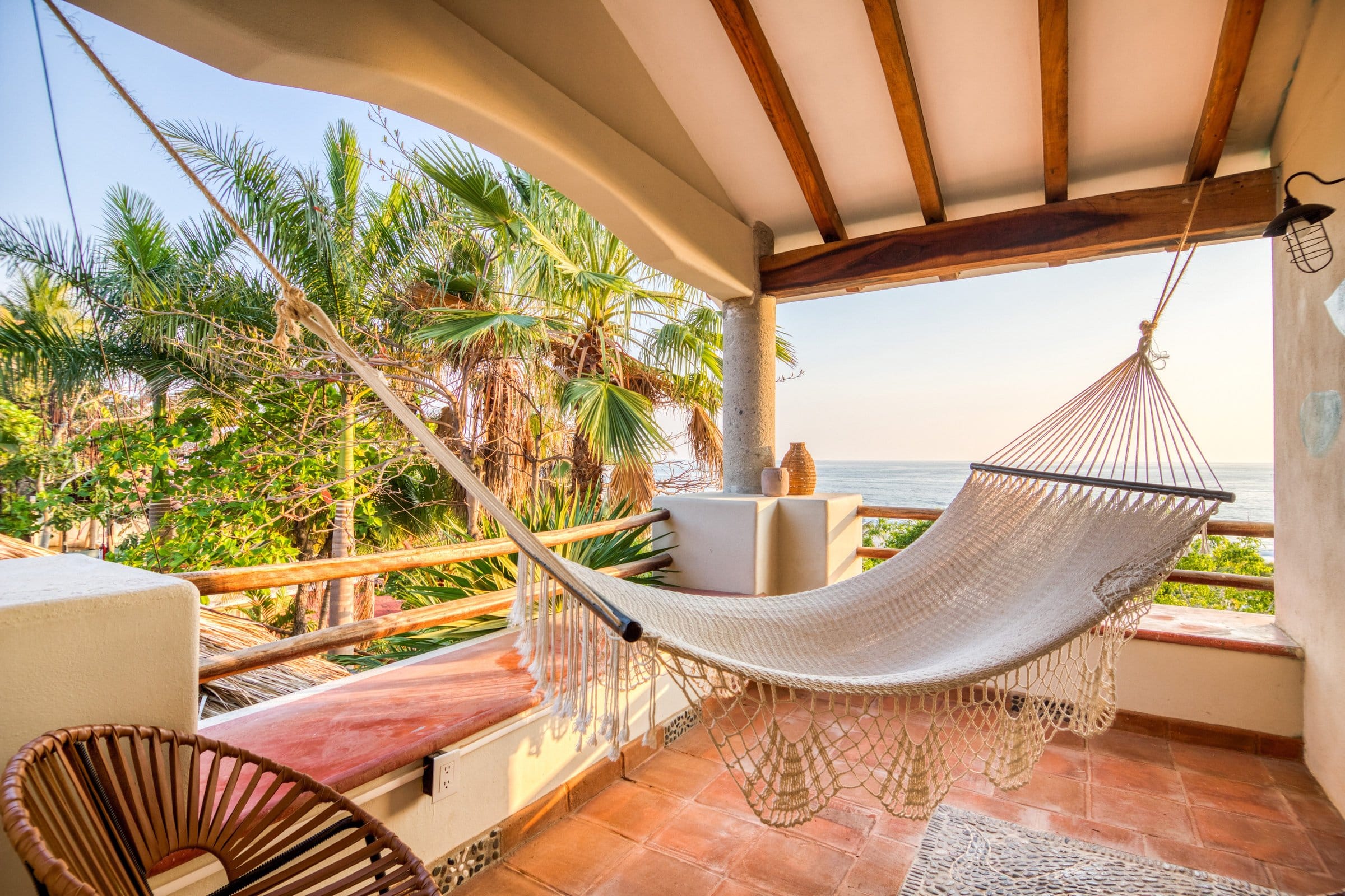 Hammock on private balcony with ocean view and palm trees at Selina Puerto Escondido