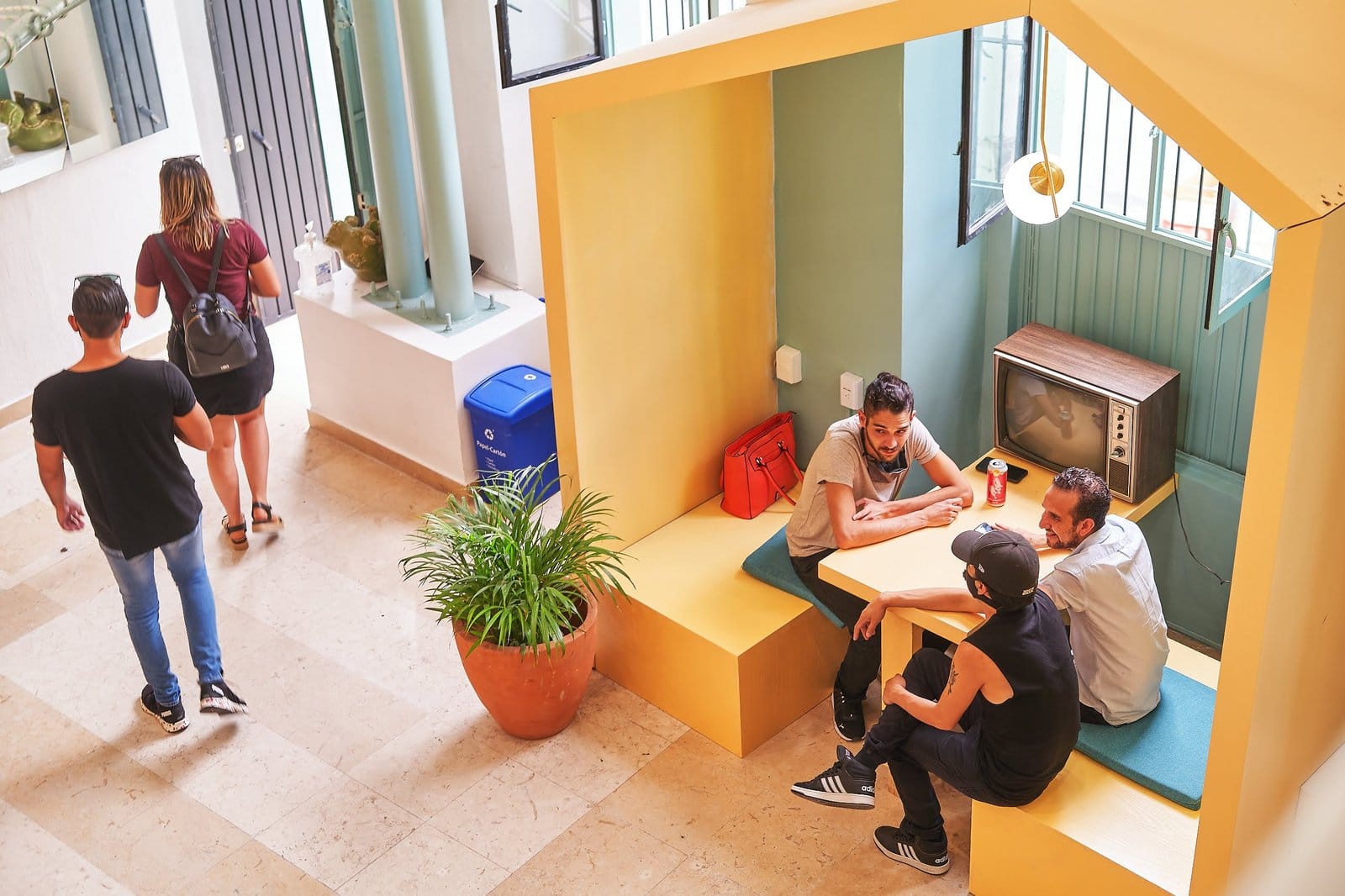 Residents hanging out in the yellow house-shaped lounge nook at Nora Coliving Guadalajara