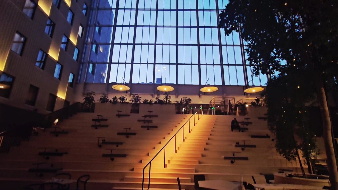 Dramatic tiered seating area with city view at dusk inside VALO Hotel & Work
