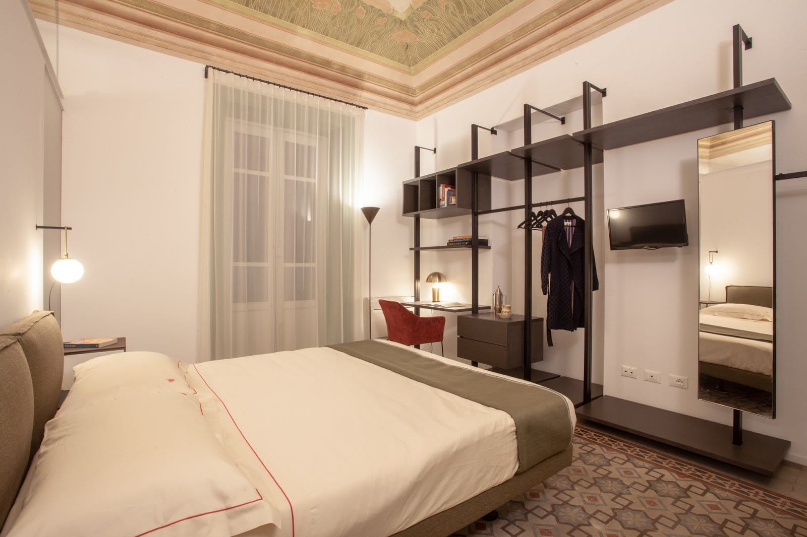 BeetCommunity bright bedroom with frescoed ceiling, open wardrobe shelving and a writing desk