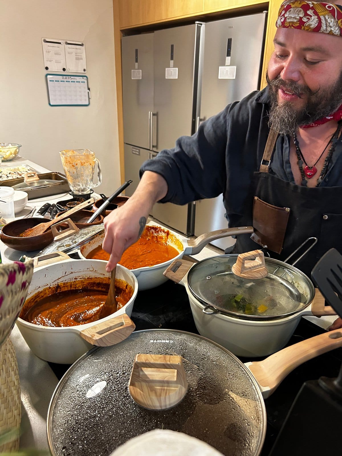 Chef preparing mole negro in the shared kitchen at Outsite Oaxaca City — communal cooking event