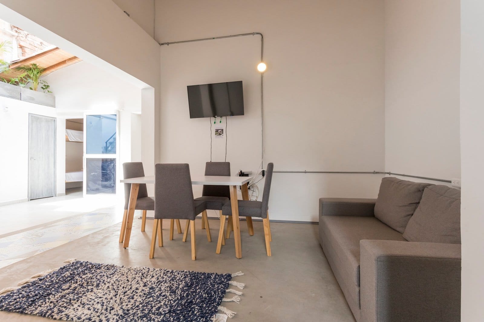 Common living area at Gastón Coliving with dining table, couch, and TV