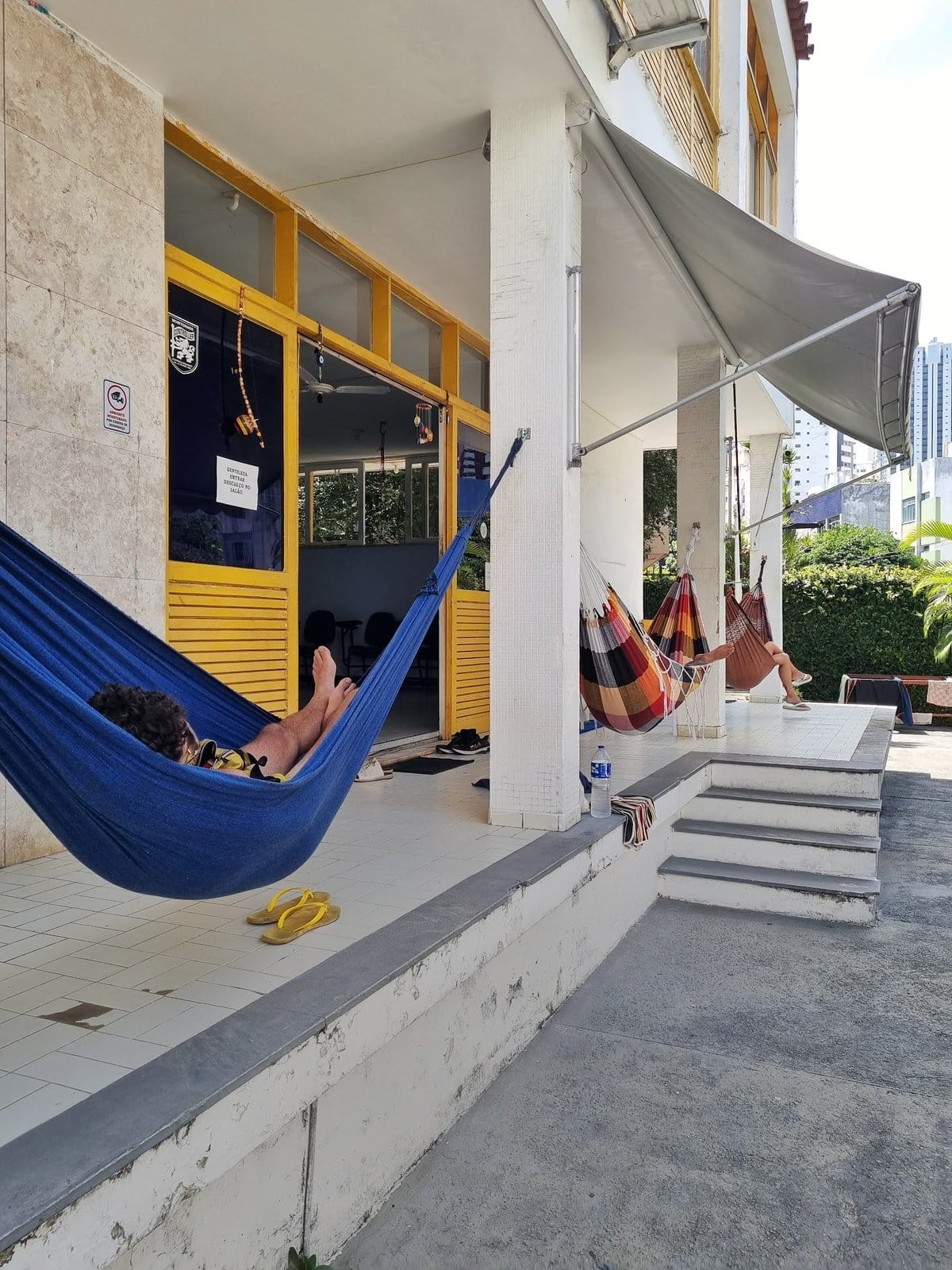Guests relaxing in hammocks on the porch at Nomads Multiespaço, Salvador