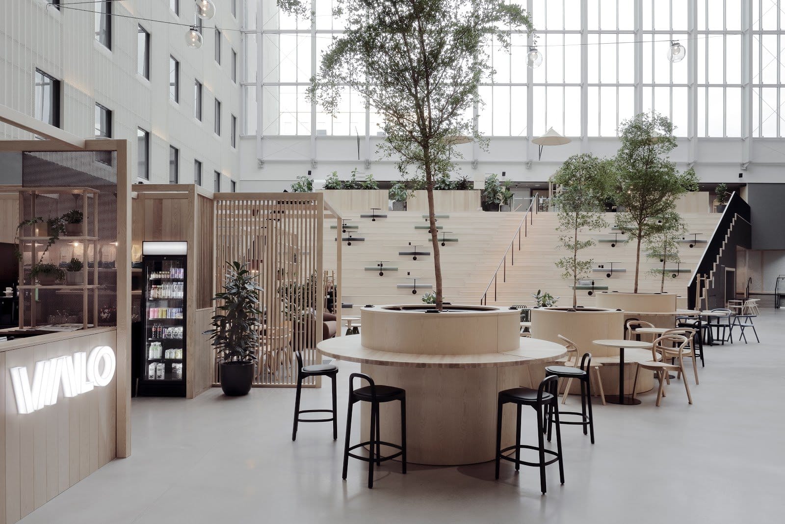 Spacious modern coworking area with circular tables and laptops at VALO Hotel & Work
