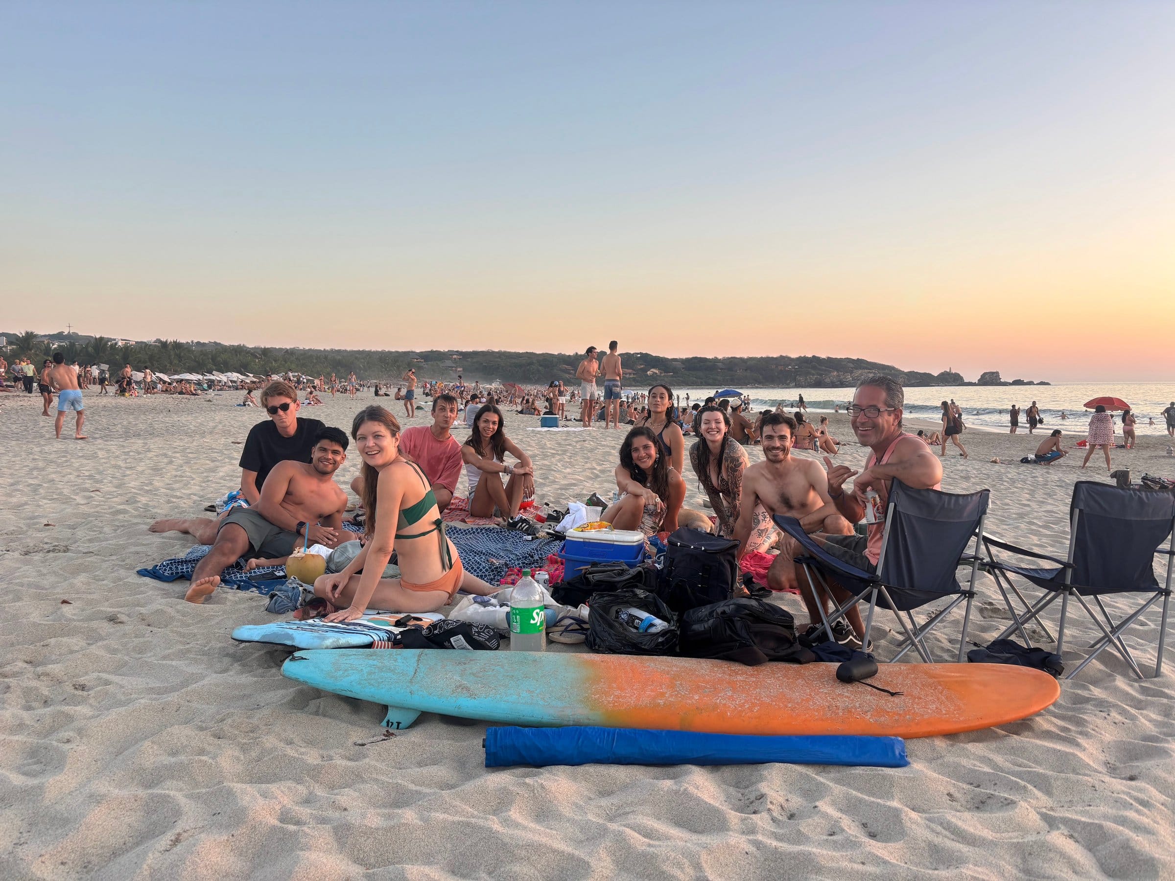 El Mundito community on Playa Zicatela at sunset with surfboards — the beach lifestyle at Puerto Escondido