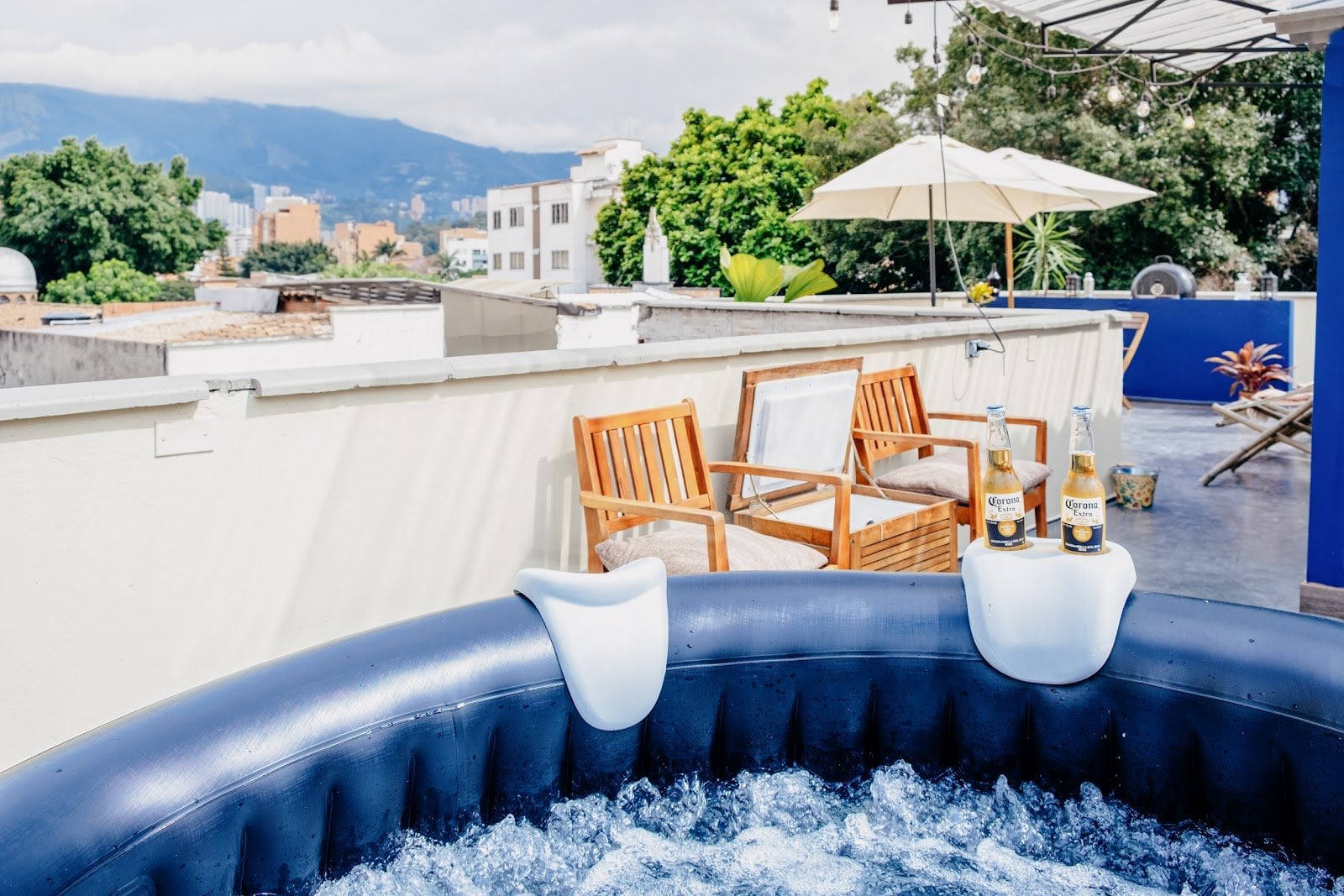 Rooftop terrace with a hot tub and lounge chairs overlooking the Medellin mountains at Balu Coliving