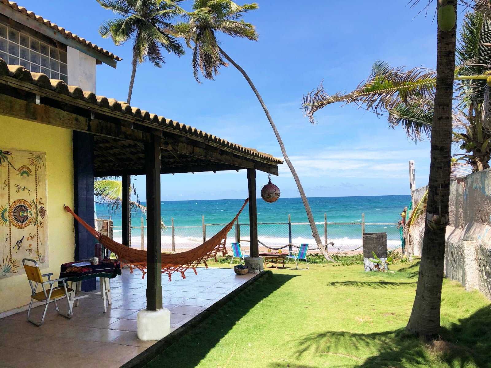 INFINIColiving beachfront veranda with hammock overlooking the lawn and ocean in Camaçari, Brazil