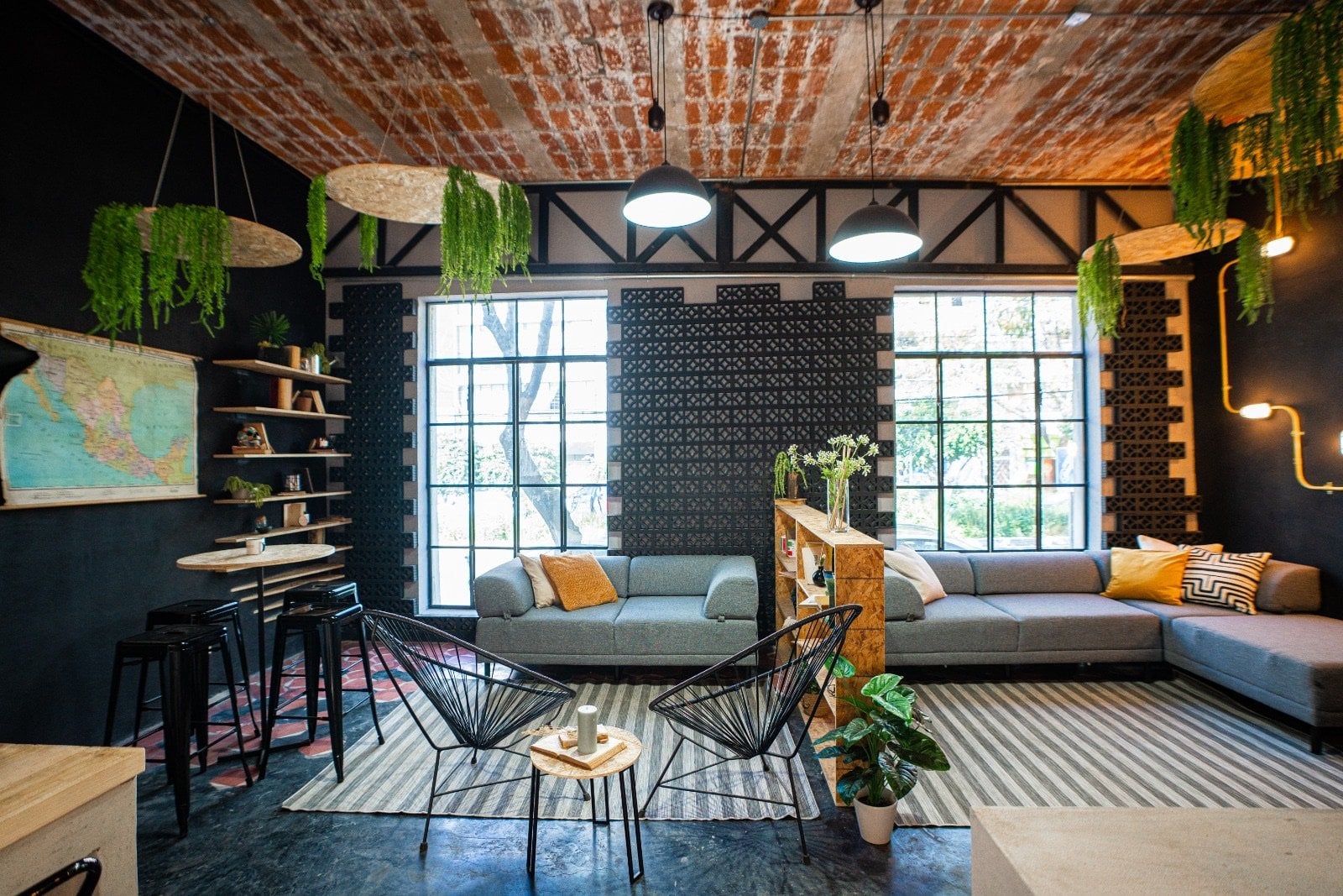 The main common lounge at U-Co Roma with its spectacular exposed terracotta brick barrel-vault ceiling, industrial windows and hanging ferns